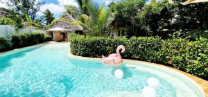 吉汶瓦ARYA Boutique Resort的一座房子里游泳池里的粉色天鹅