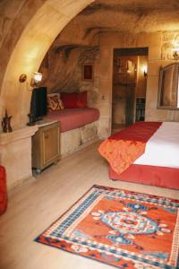奥塔希萨尔Elaa Cave Hotel的一间卧室配有床、电视和地毯。