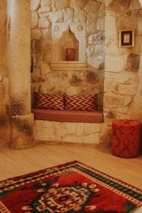 奥塔希萨尔Elaa Cave Hotel的一间设有石头壁炉的客房,地板上铺有地毯