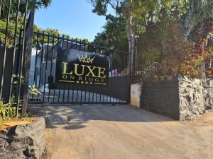 德班Luxe on Ridge Boutique Hotel的黑色铁门,上面有标志