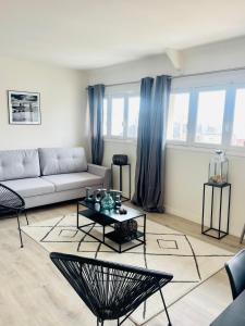 多维尔Deauville Serenity - Spacieux & Chic à Place Morny的客厅配有沙发和桌子