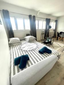 多维尔Deauville Serenity - Spacieux & Chic à Place Morny的一张大床,上面有两个蓝色的枕头