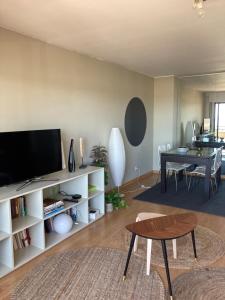 马托西纽什Oporto beach apartment的客厅配有电视和桌子