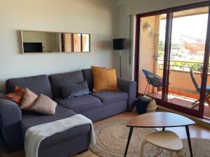 马托西纽什Oporto beach apartment的客厅配有蓝色的沙发和桌子