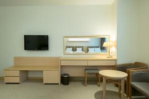 首尔首尔G地酒店的酒店客房配有书桌和电视。