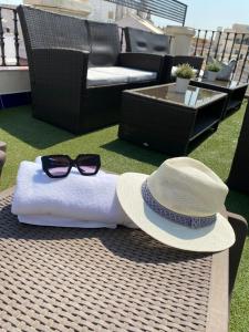 塞维利亚广场酒店的坐在桌子上的帽子和太阳镜