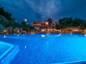 诺瓦利娅Resort Trcol的一座大楼前的大型游泳池