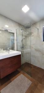 木洛希尼Holiday house Manoka的一间带水槽和玻璃淋浴的浴室