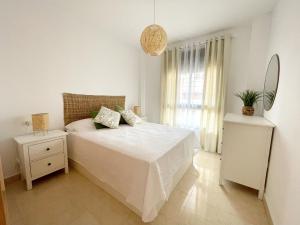 圣玛丽亚港El Arrecife - Apartamento a 2 minutos de la playa en El Puerto de Santamaría的白色的卧室设有床和窗户