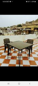 乌代浦Nandini Paying Guest House的一张乒乓球桌和两把椅子位于地板上