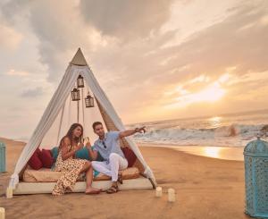 马哈巴利普拉姆金奈马哈巴利普兰洲际度假村的坐在海滩上的圆锥形帐篷里的男女