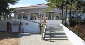 布朗库堡Hotel Campo do Rosmaninho的白色的房子,有楼梯和盆栽植物