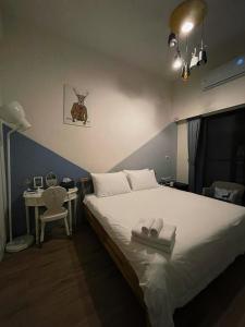 东港东帆巷弄休闲民宿的一间卧室配有一张床和一张桌子及椅子