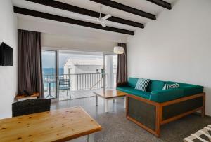 萨尔加AluaSun Far Menorca的客厅配有绿色沙发和桌子