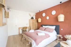 波尔多Les pénates bordelaises - Maison d'hôtes - Guesthouse的一间卧室配有一张带粉红色床单的大床