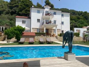 班约勒Villa Joy 4ever的一座房子前游泳池旁的雕像