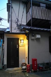 Giommachi東山の宿 藤屋的一座带黑色门和阳台的建筑