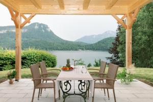 阿尔陶塞Villa Frischmuth am See的湖景庭院配有桌椅