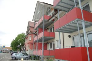 博登斯边的拉多夫采尔Gasthof Seerose的一座红色和白色的建筑,旁边设有停车场