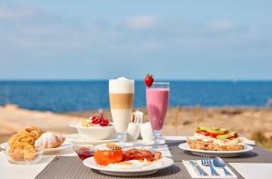科洛尼亚圣霍尔迪卡布布兰科环球酒店 - 仅限成人的海滩上一张桌子,上面放着食物和饮料
