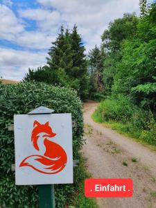 NossenJägerhaus的一条土路旁的标志上有一个红色狐狸