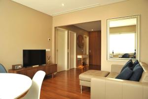 波尔图Apartamento da Musica - Boavista - OPENING的客厅配有白色沙发和电视
