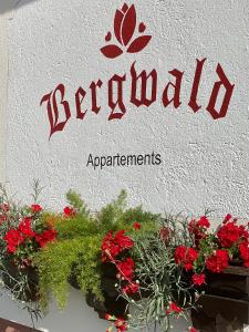 阿尔卑巴赫贝尔格瓦尔德酒店的建筑上的一个红花标志