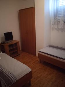 DobravljeTuristična kmetija Birsa的一间卧室配有两张床和一张带电脑的书桌
