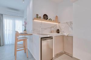 安迪帕罗斯岛Nautica suites - Executive suite with jacuzzi的厨房配有水槽和带凳子的台面