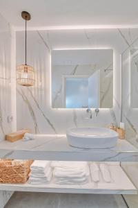 安迪帕罗斯岛Nautica suites - Executive suite with jacuzzi的白色的浴室设有水槽和镜子