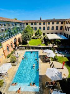 蒙托邦Abbaye des Capucins Spa & Resort的一个大型游泳池,里面有人