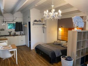 赫尔Vakantiehuisje De Waterhoek的一间卧室配有一张床、一张桌子和一个吊灯。