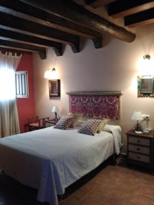 莱图尔Casa Rural la Escalera的一间卧室设有一张大床和红色的墙壁