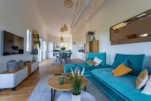 派拉索梅O'DYSSEE Appartement vue panoramique Bassin d'Arcachon的客厅配有蓝色的沙发和桌子