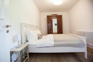 基茨比厄尔Kitz Apartments的卧室配有白色的床和木制床头板
