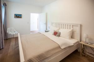 基茨比厄尔Kitz Apartments的卧室配有白色大床和白色枕头