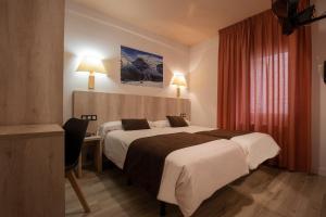 马萨纳Hotel Marco Polo的酒店客房配有两张床和一张书桌