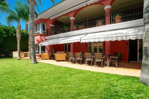 穆特克萨梅尔10 Bedroom 5 Star Luxury Villa & Heated Pool for 5 to 30 Guests near Alicante的草坪上带桌椅的度假村