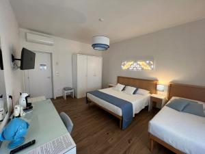 奥特朗托B&B Venti di Mare的一间卧室配有两张床和一张书桌及电视