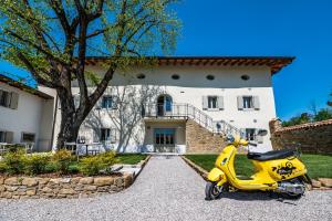 戈里齐亚Borgo Gradis'ciutta的停在房子前面的黄色摩托车