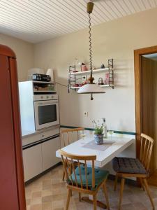 穆勒克Ferienwohnung Eva的厨房配有桌椅和炉灶。