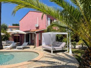 圣马克西姆Fantastic pool villa 900m to the beach; with extravagant big garden的一座房子旁的游泳池,配有两把躺椅