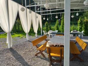 比卡兹凯Pensiunea Aurelia的庭院配有桌椅和白色窗帘