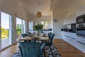 派拉索梅O'DYSSEE Appartement vue panoramique Bassin d'Arcachon的厨房配有木桌和绿色椅子
