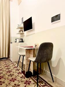 莱切Eccelsoleccese的客房设有一张桌子、一台电脑和两把椅子