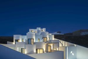 奥诺斯CUBIC Mykonos Seafront Design Suites的白色的建筑在晚上点亮