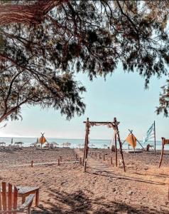 根纳迪Eco Beach And Magic Garden Hotel的沙滩上,沙中有一个木拱