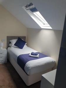 巴茅思Leamington House的一间卧室配有一张带蓝色枕头的床和一扇窗户。