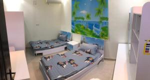 Ithnaynفلل فندقية بمدينة تنومة的一间设有两张床的客房,墙上挂着一幅画