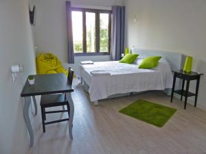 巴塞罗那BCN体育旅馆的一间卧室配有一张带绿色枕头的床和一张桌子